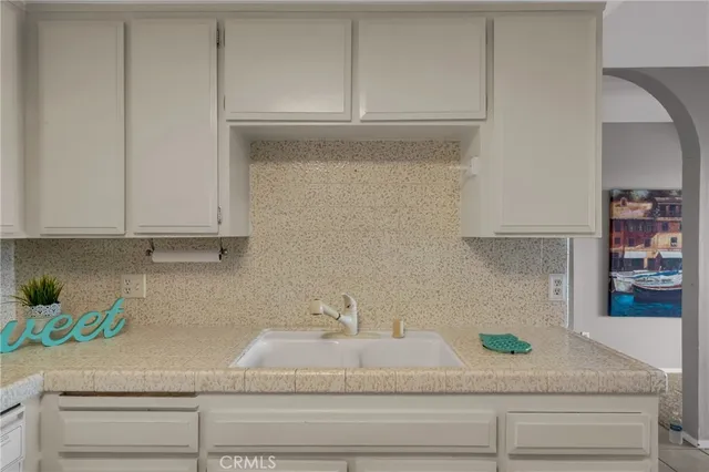 a kitchen with white cabinets and a sink