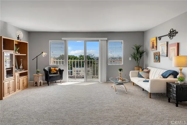 a living room with furniture and a large window with garden view