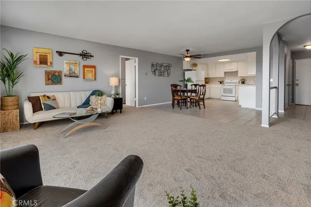 a living room with furniture and a dining table with kitchen view