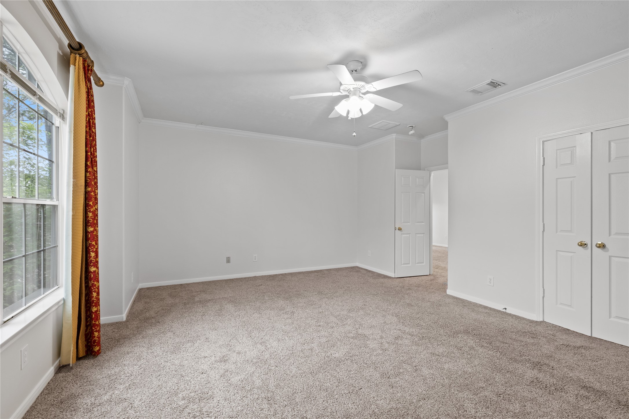 107 West Burberry Circle The Woodlands, TX 77384 - Photo 14 of 28 an empty room with a window and a chandelier fan