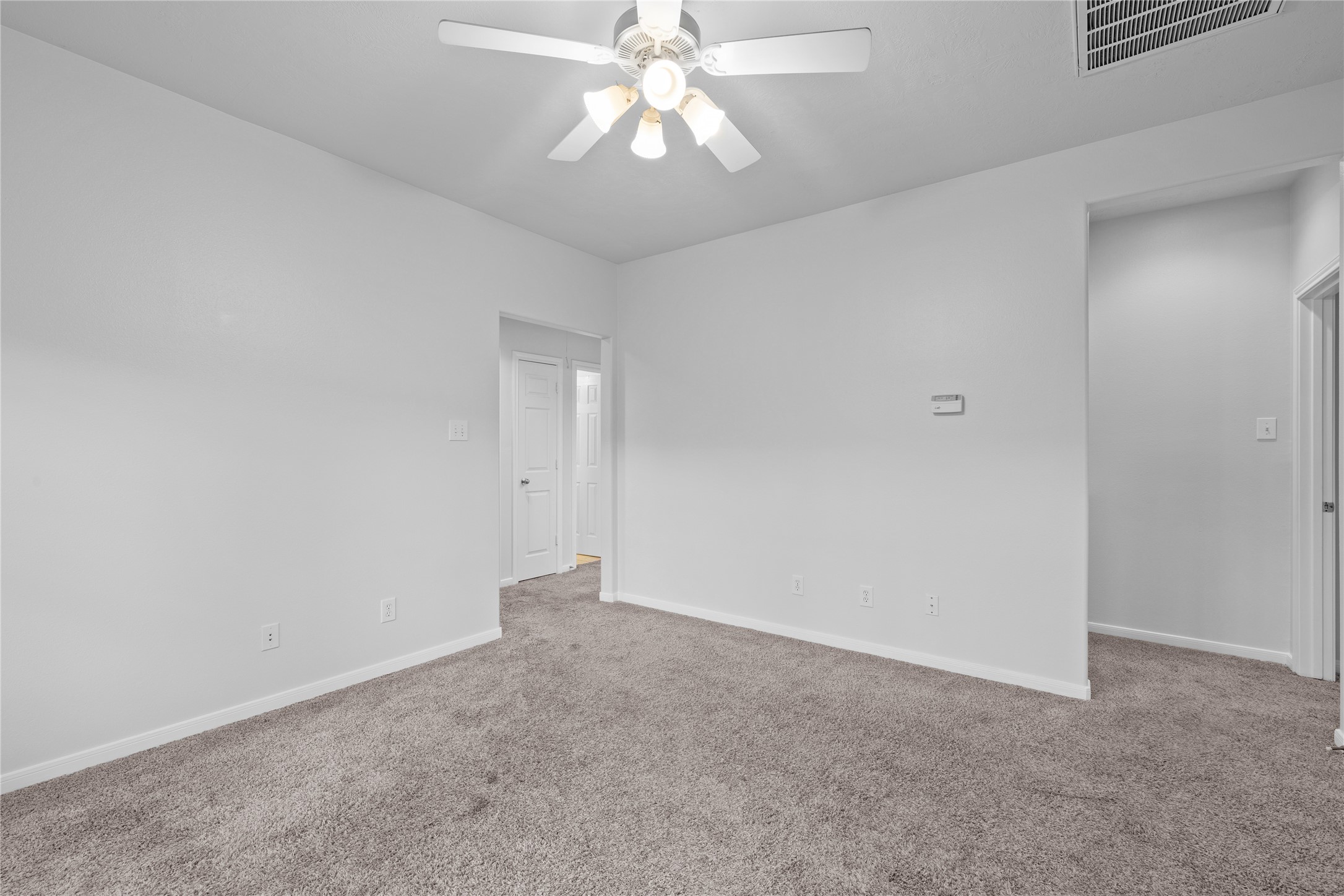 107 West Burberry Circle The Woodlands, TX 77384 - Photo 21 of 28 an empty room with a chandelier fan and windows