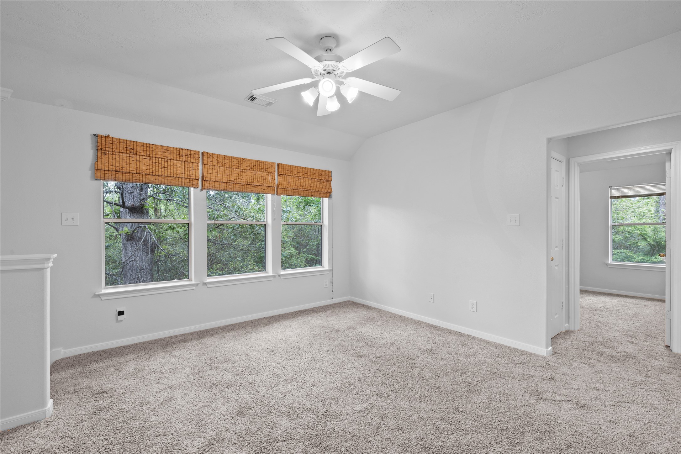 107 West Burberry Circle The Woodlands, TX 77384 - Photo 9 of 28 an empty room with windows and chandelier fan