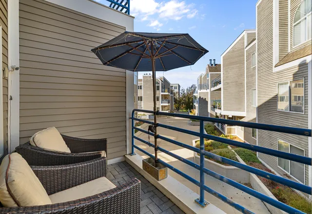 a view of a roof deck with couches under an umbrella