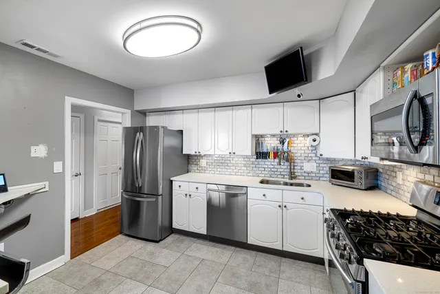 a kitchen with granite countertop a sink stainless steel appliances and cabinets