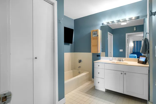 a bathroom with a bathtub a double vanity sink and mirrors