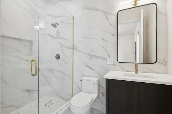 a bathroom with a sink a toilet and shower