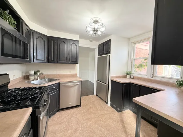 a kitchen with stainless steel appliances granite countertop a refrigerator and a sink