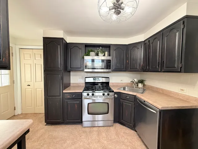 a kitchen with stainless steel appliances a stove a microwave and a sink