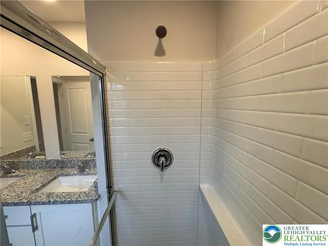 a bathroom with a granite countertop sink and mirror
