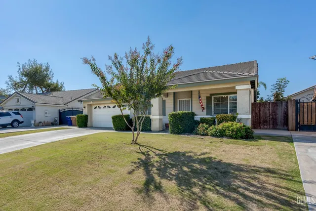a front view of a house with a yard and potted plants