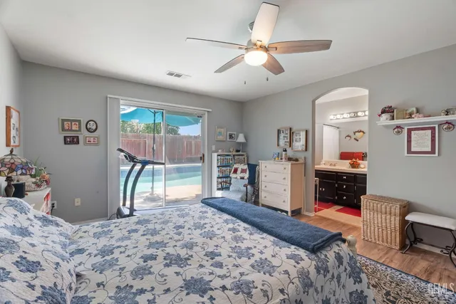 a bedroom with a bed a dresser and flat screen tv