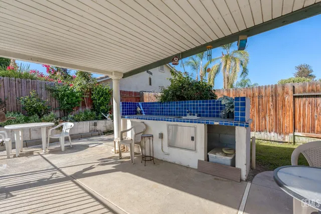 a view of a patio with table and chairs with wooden floor and fence