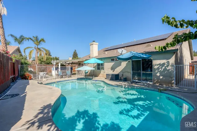 a view of a house with swimming pool and sitting area