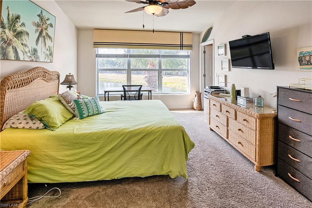 16211 Ravina Way, Unit 18 Naples, FL 34110 - Photo 11 of 24 a spacious bedroom with a bed a window and a flat screen television