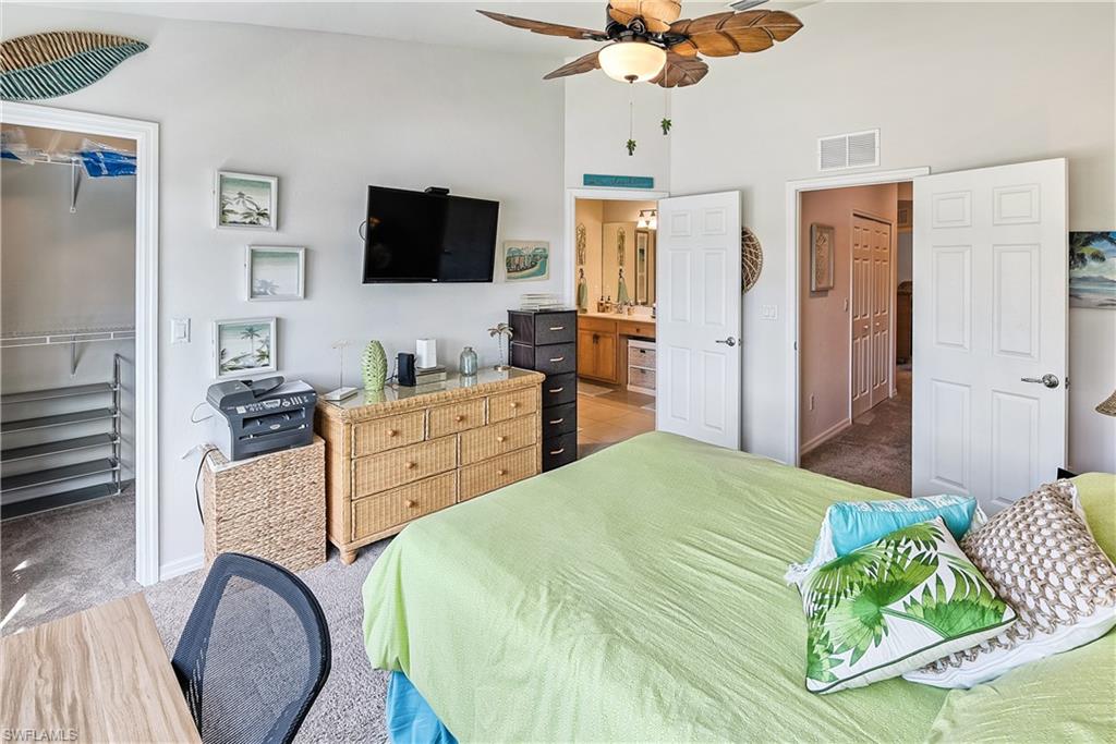 16211 Ravina Way, Unit 18 Naples, FL 34110 - Photo 12 of 24 a spacious bedroom with a bed and a flat screen tv