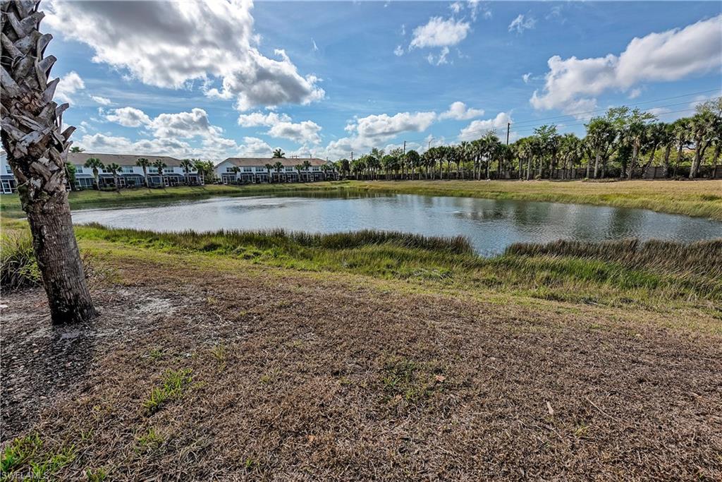 16211 Ravina Way, Unit 18 Naples, FL 34110 - Photo 20 of 24 a view of a lake with houses in the back