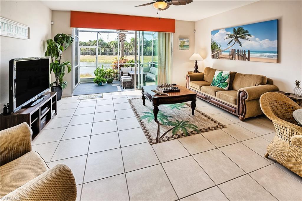 16211 Ravina Way, Unit 18 Naples, FL 34110 - Photo 4 of 24 a living room with patio furniture and a flat screen tv