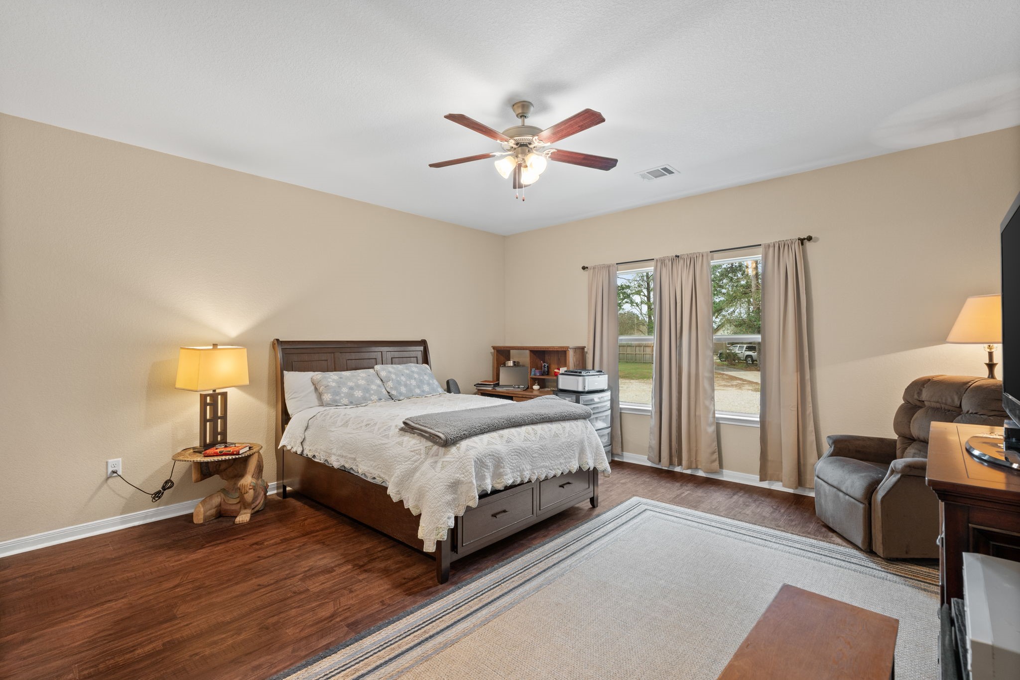 11706 Bogs Court Tomball, TX 77375 - Photo 12 of 42 a spacious bedroom with a bed and a chandelier