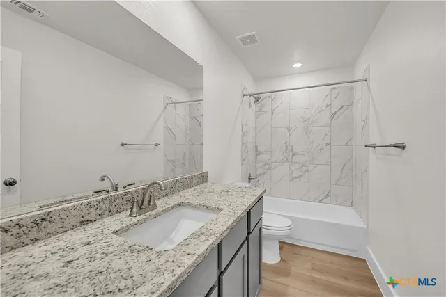 a bathroom with a granite countertop sink toilet and shower