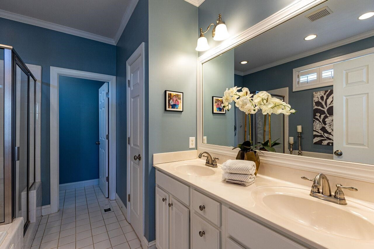 Double sinks and framed mirror. Neutral tile and fixtures. Master Bath/Spa