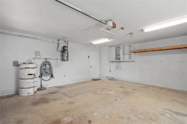 an aerial view of a house with swimming pool and large trees