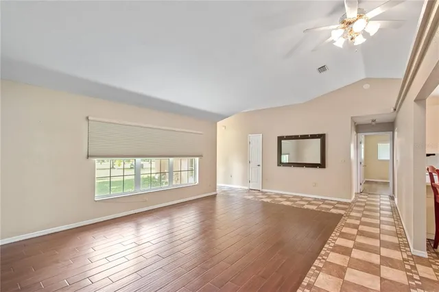 a view of empty room with wooden floor