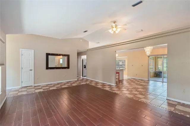 a large white kitchen with granite countertop a sink and a chandelier