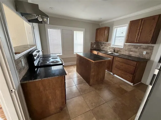 a kitchen with stainless steel appliances granite countertop a refrigerator a stove and a sink