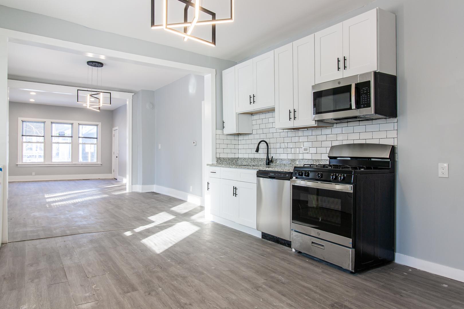 2659 West Homer Street, Unit 1F Chicago, IL 60647 - Photo 2 of 14 a kitchen with stainless steel appliances granite countertop a stove a sink and a microwave