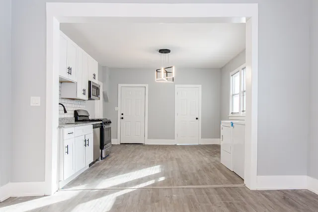 a view of a kitchen with a sink dishwasher stove and cabinets