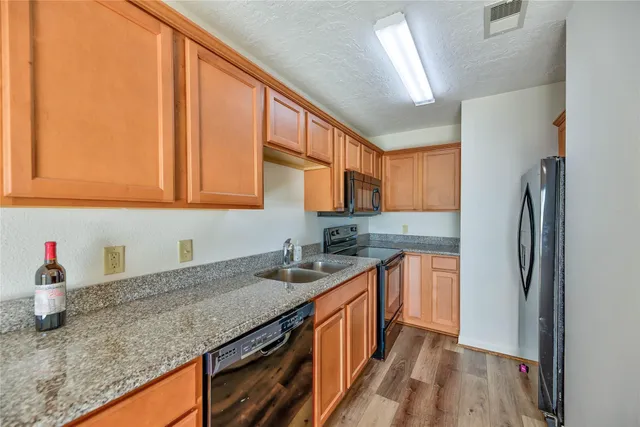 an empty room with wooden floor and cabinet