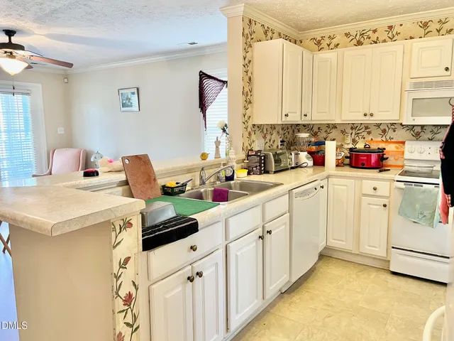 a kitchen with white cabinets and white appliances