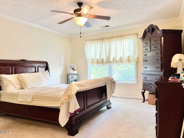 a bedroom with a bed dresser and a window