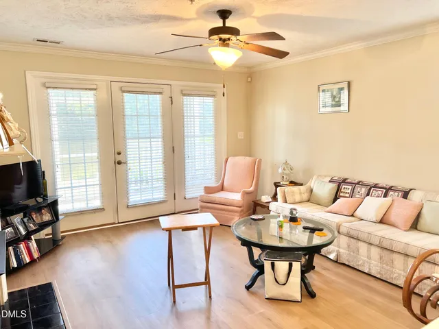 a living room with furniture a flat screen tv and a window
