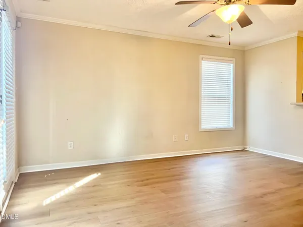an empty room with a ceiling fan and windows