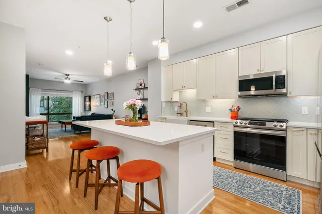 a kitchen with stainless steel appliances a stove a sink a microwave a refrigerator and cabinets