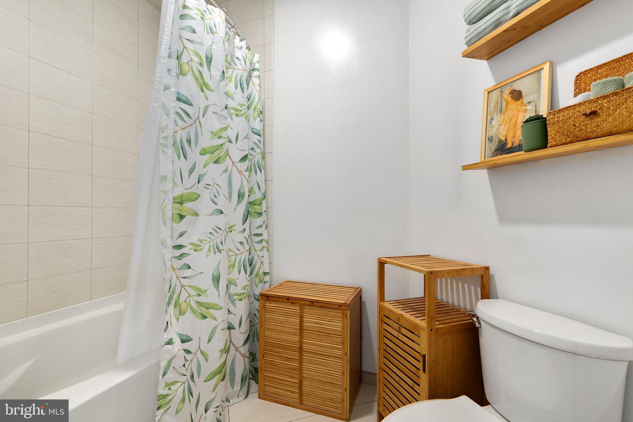 8005 13th Street, Unit 202 Silver Spring, MD 20910 - Photo 17 of 30 a bathroom with a toilet and a shower curtain