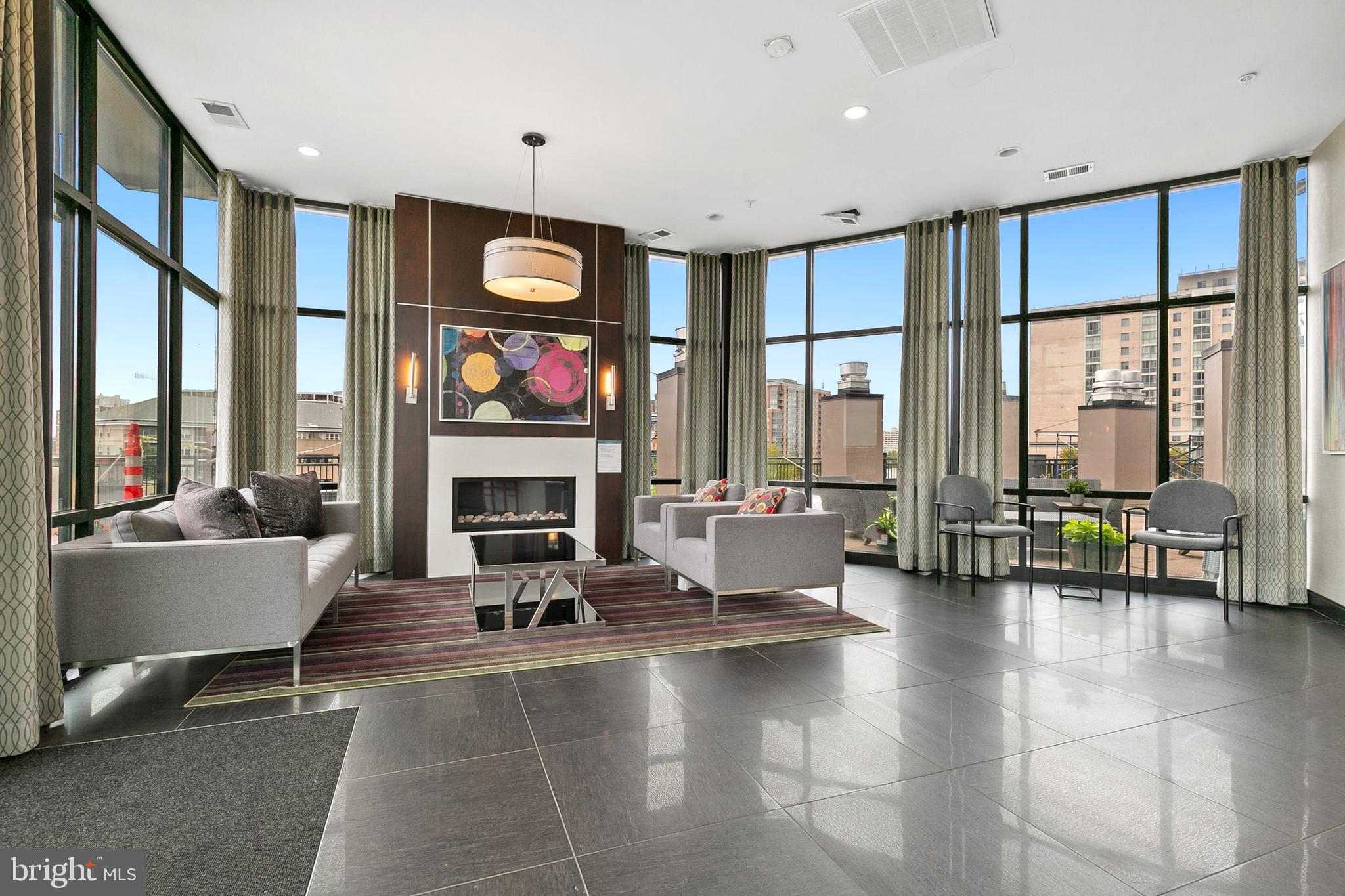 8005 13th Street, Unit 202 Silver Spring, MD 20910 - Photo 22 of 30 a living room with fireplace furniture and large windows