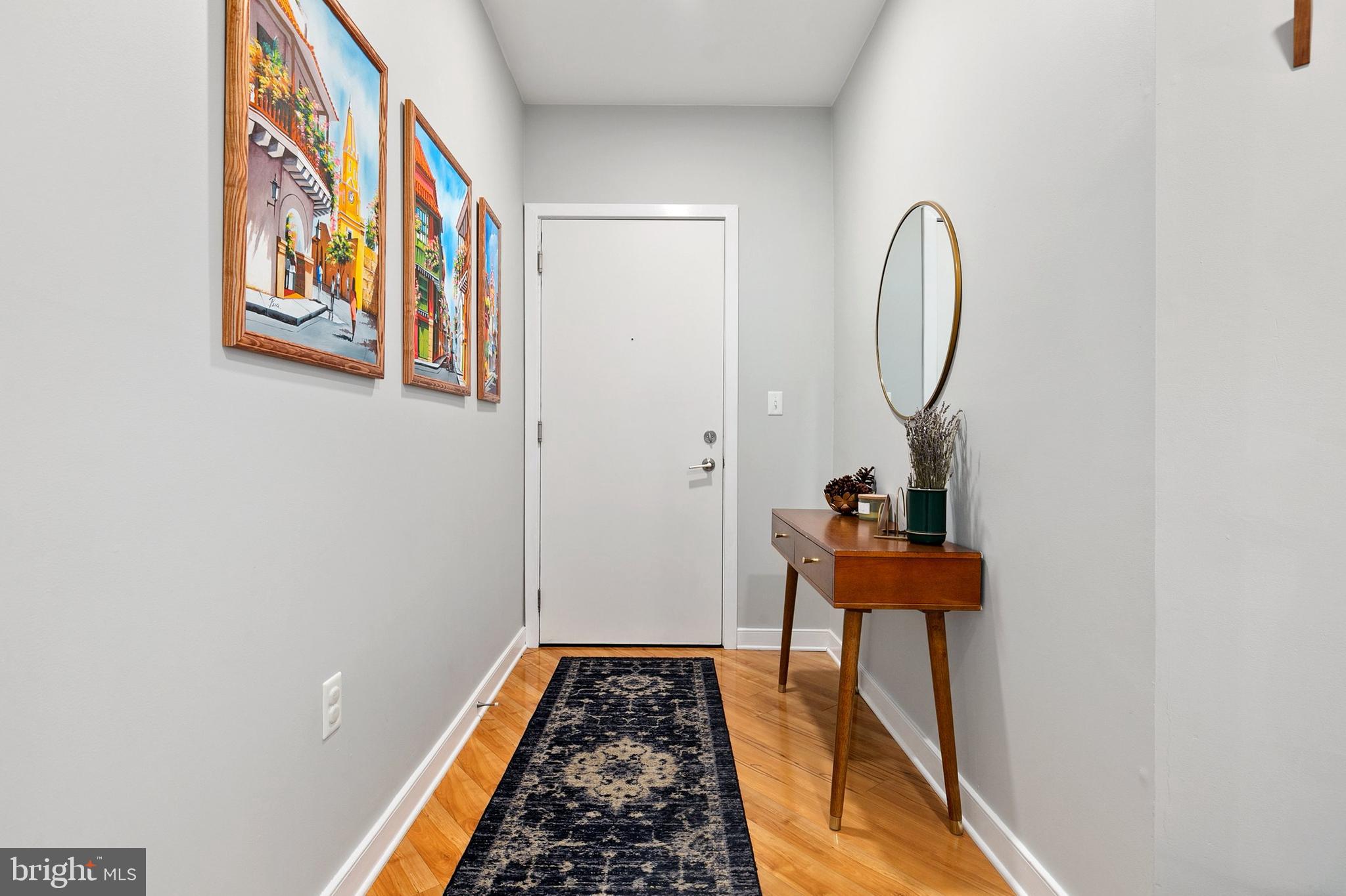 8005 13th Street, Unit 202 Silver Spring, MD 20910 - Photo 3 of 30 a view of a hallway with paintings on the wall