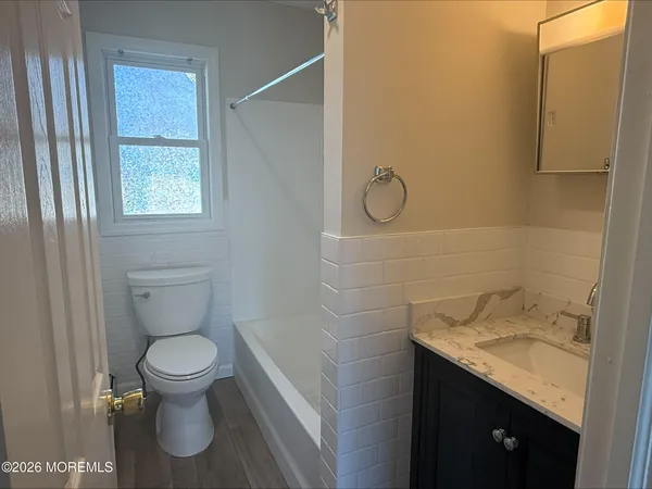 a bathroom with a granite countertop toilet and a sink