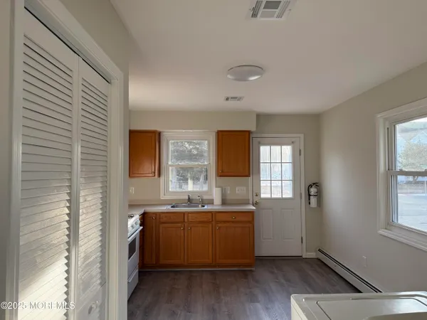 a view of a kitchen with a sink dishwasher and wooden floor