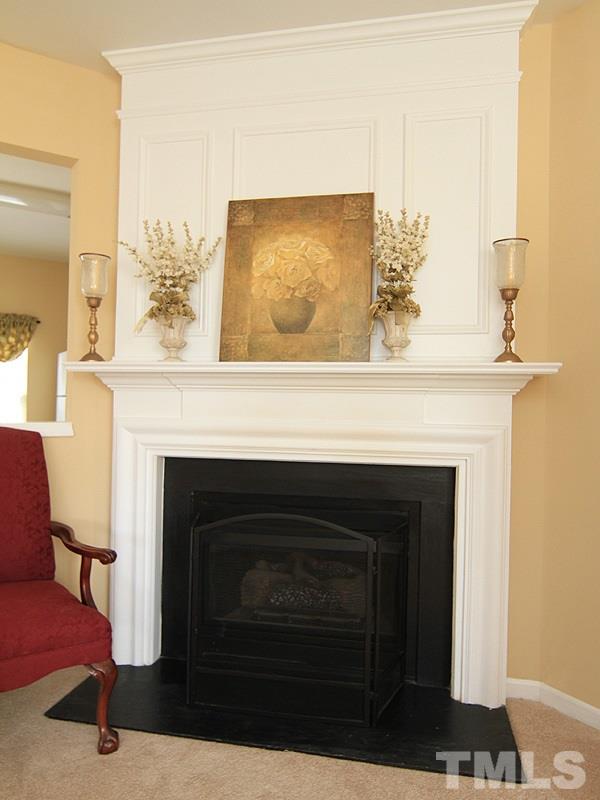 5349 Glen Canyon Road Raleigh, NC 27616 - Photo 4 of 14 a fireplace with a vase on top of it