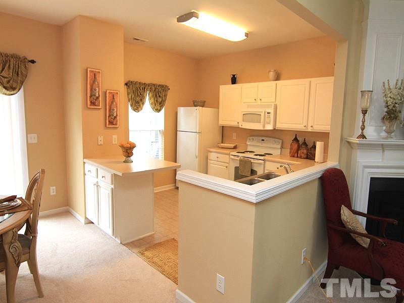 5349 Glen Canyon Road Raleigh, NC 27616 - Photo 6 of 14 a kitchen with a refrigerator a stove a sink dishwasher with a dining table and chairs