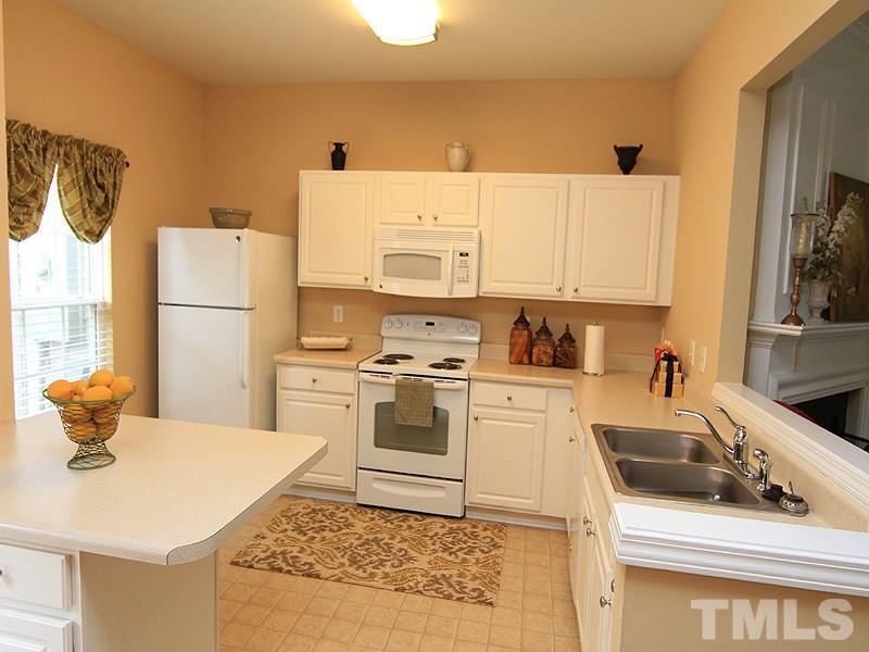5349 Glen Canyon Road Raleigh, NC 27616 - Photo 7 of 14 a kitchen with a sink a stove and white cabinets