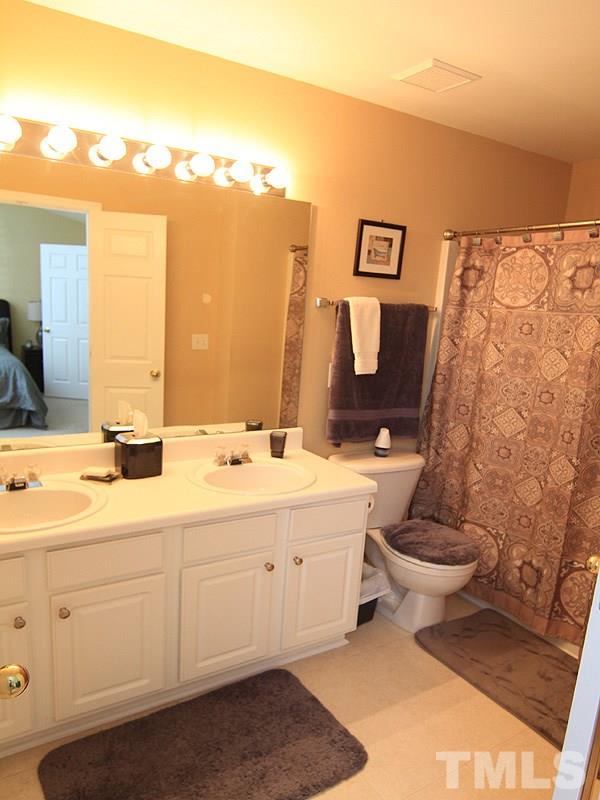 5349 Glen Canyon Road Raleigh, NC 27616 - Photo 10 of 14 a spacious bathroom with a toilet sink and mirror