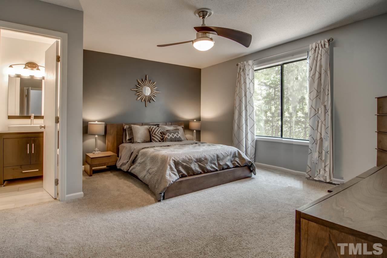 6805 Chamonix Place Raleigh, NC 27613 - Photo 14 of 29 a bedroom with a bed and a chandelier