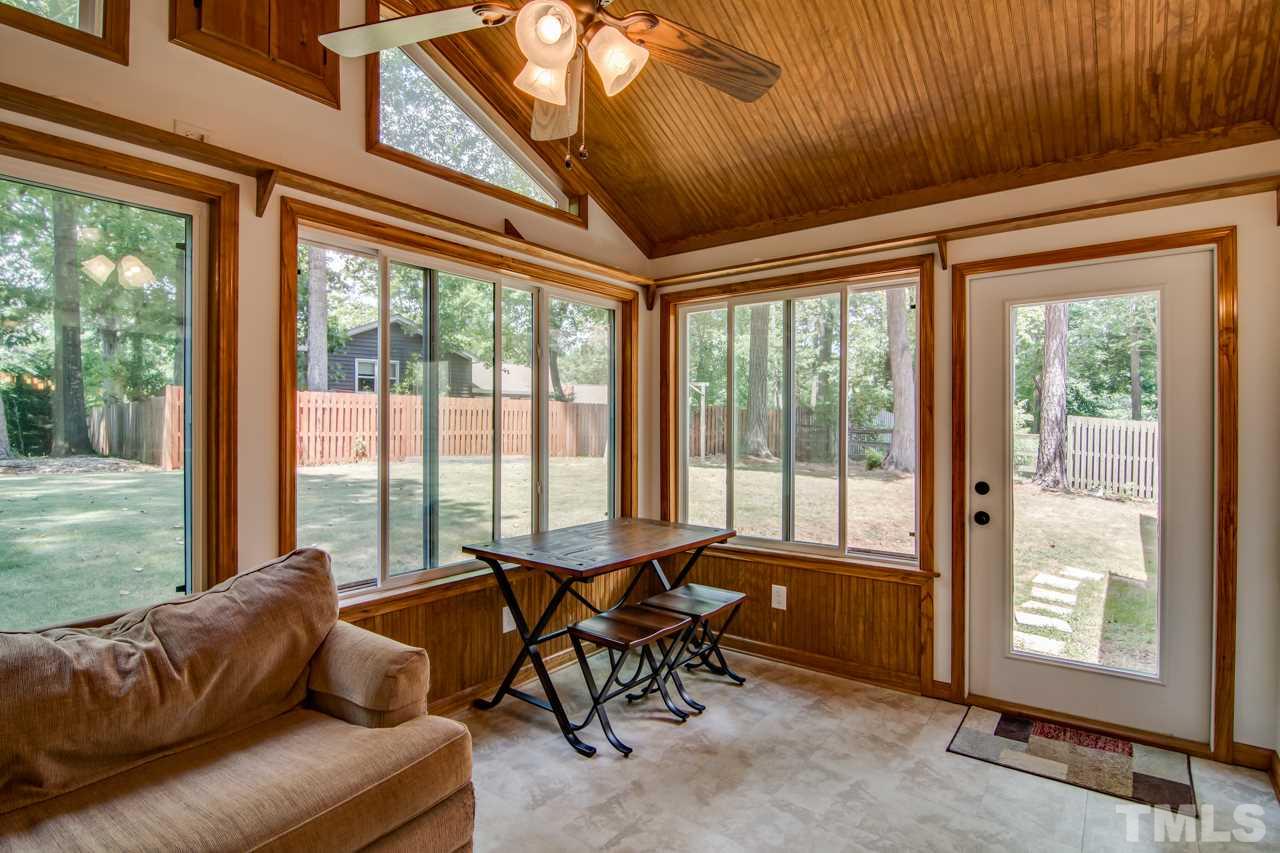 6805 Chamonix Place Raleigh, NC 27613 - Photo 22 of 29 a living room with furniture and floor to ceiling windows