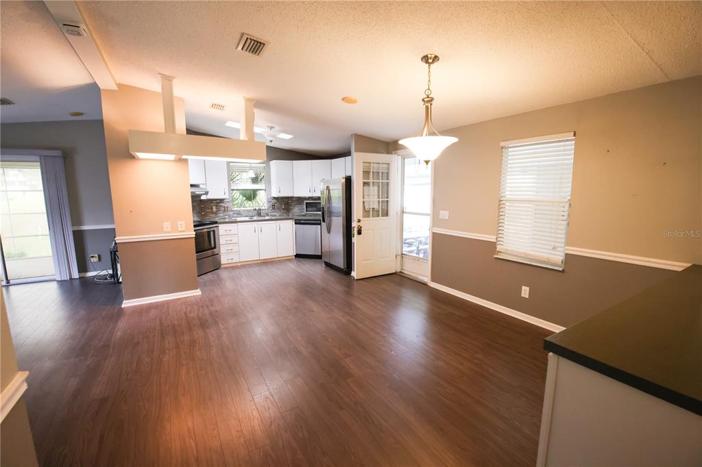 912 Orchid Street The Villages, FL 32159 - Photo 5 of 20 a kitchen with stainless steel appliances a refrigerator sink and wooden floor