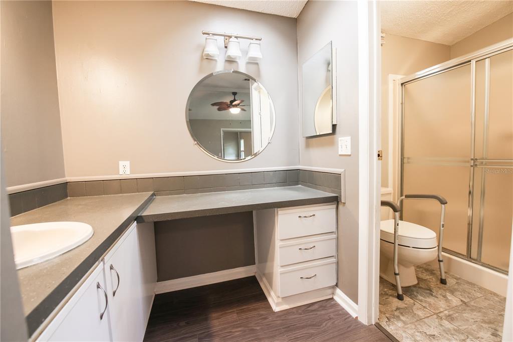 912 Orchid Street The Villages, FL 32159 - Photo 8 of 20 a spacious bathroom with a sink a toilet and a mirror
