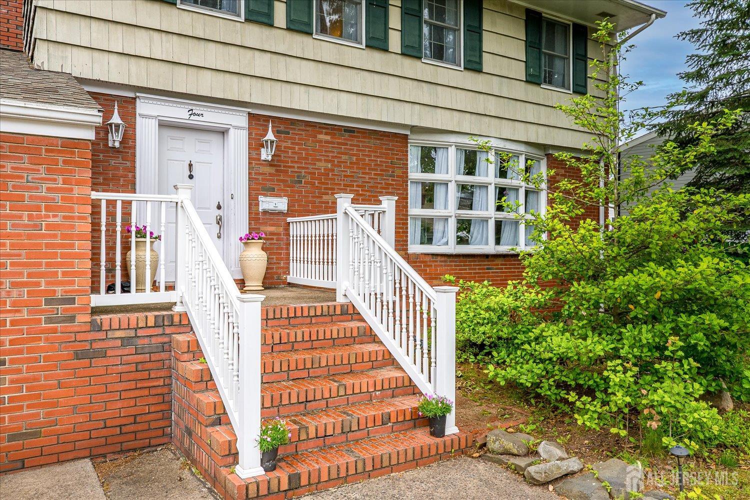 4 Bodnarik Road Edison, NJ 08837 - Photo 4 of 41 a view of a brick house with many windows next to a road